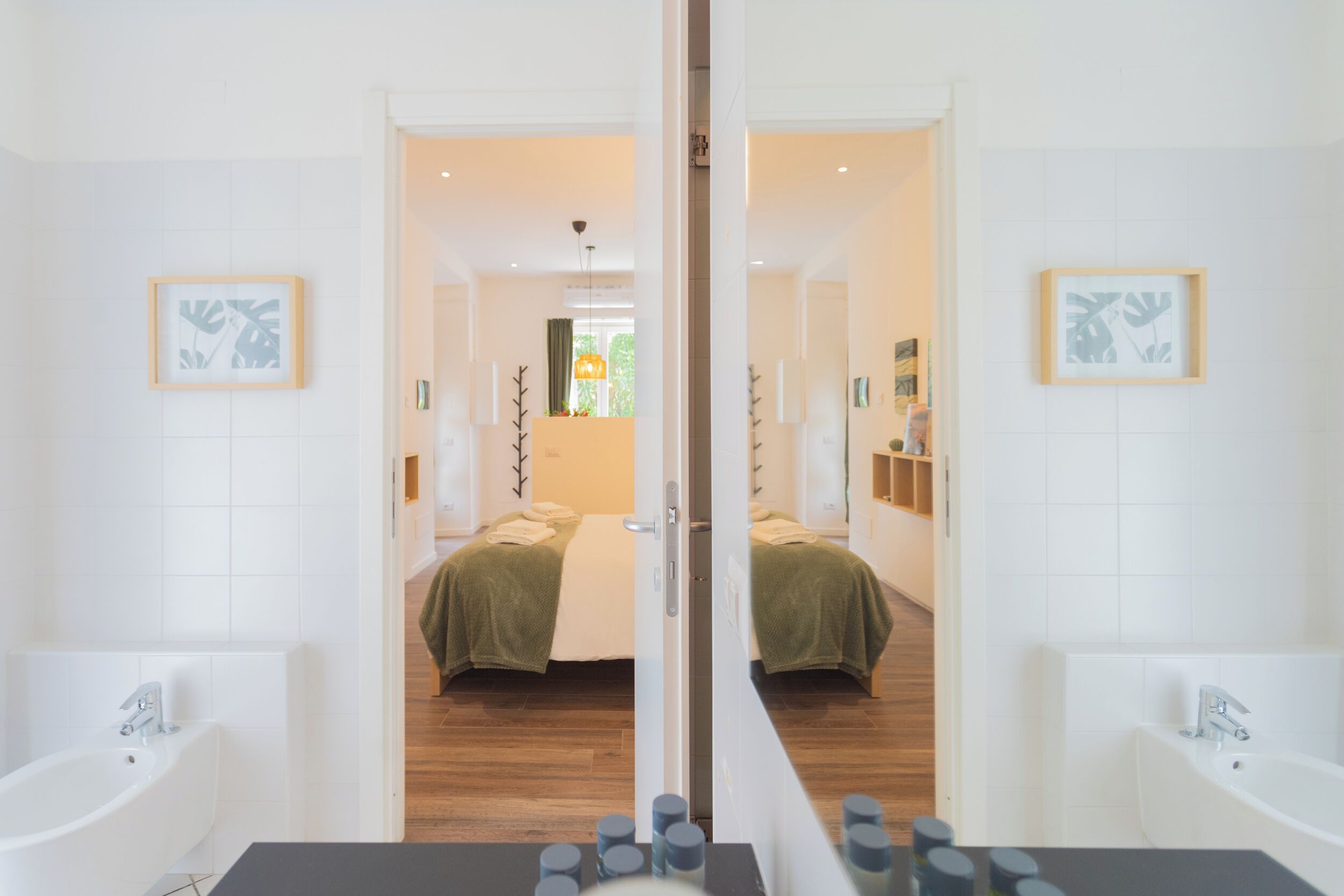 Een moderne badkamer met een grote spiegel, twee wasbakken en een bad.