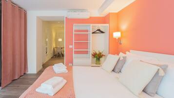 Una habitación de hotel con cama, armario, espejo y baño a la vista.