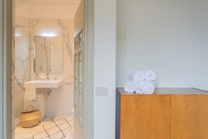 A bathroom with a marble sink, a wooden vanity, and a mirror.