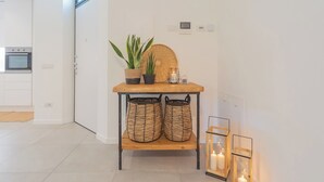 A modern kitchen with white cabinets, a built-in oven, and a small window. - Salvia & Ginepro Apartments by Rent all Como (Como)