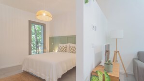 A bedroom with a bed, a window, a lamp, and a plant. - Salvia & Ginepro Apartments by Rent all Como (Como)