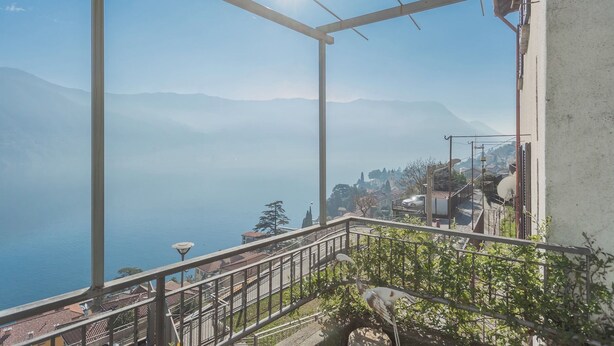 A balcony with a metal railing overlooking a mountainous landscape with a clear sky. - Giuliano's House - Amazing Lake View by Rent all Como (Laglio)