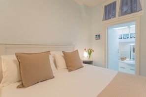 A hotel room with a bed, a nightstand, and a bathroom visible through an open door. - Il Timone by Rent all Como (Colonno)