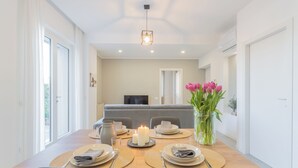 A dining area with a wooden table set for four, candles, and a vase of flowers. - Isola Felice Grandate by Rent all Como (Grandate)