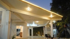 Un espacio interior amplio con techo alto, iluminación empotrada y una escalera que conduce a un nivel superior.