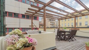 A wooden deck with a table and chairs, surrounded by potted flowers. - La Casa del Golfista by Rent all Como (Como)
