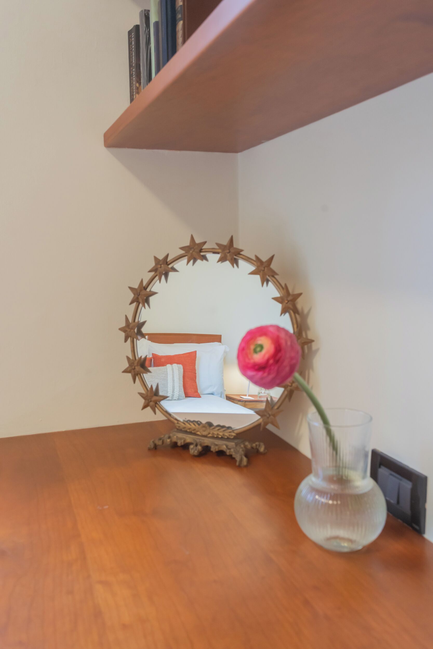 A wooden table with a glass vase containing a single flower.