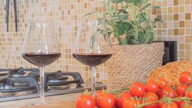 A kitchen counter with two wine glasses, a plant, and cherry tomatoes. - La Casa del Golfista by Rent all Como (Como)