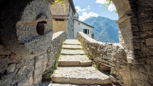 A stone staircase leading to a building with a mountain backdrop.