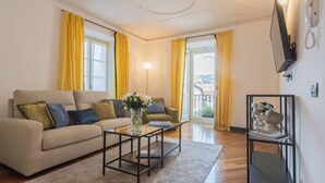 Un salon avec un canapé, une table basse et un téléviseur fixé au mur.