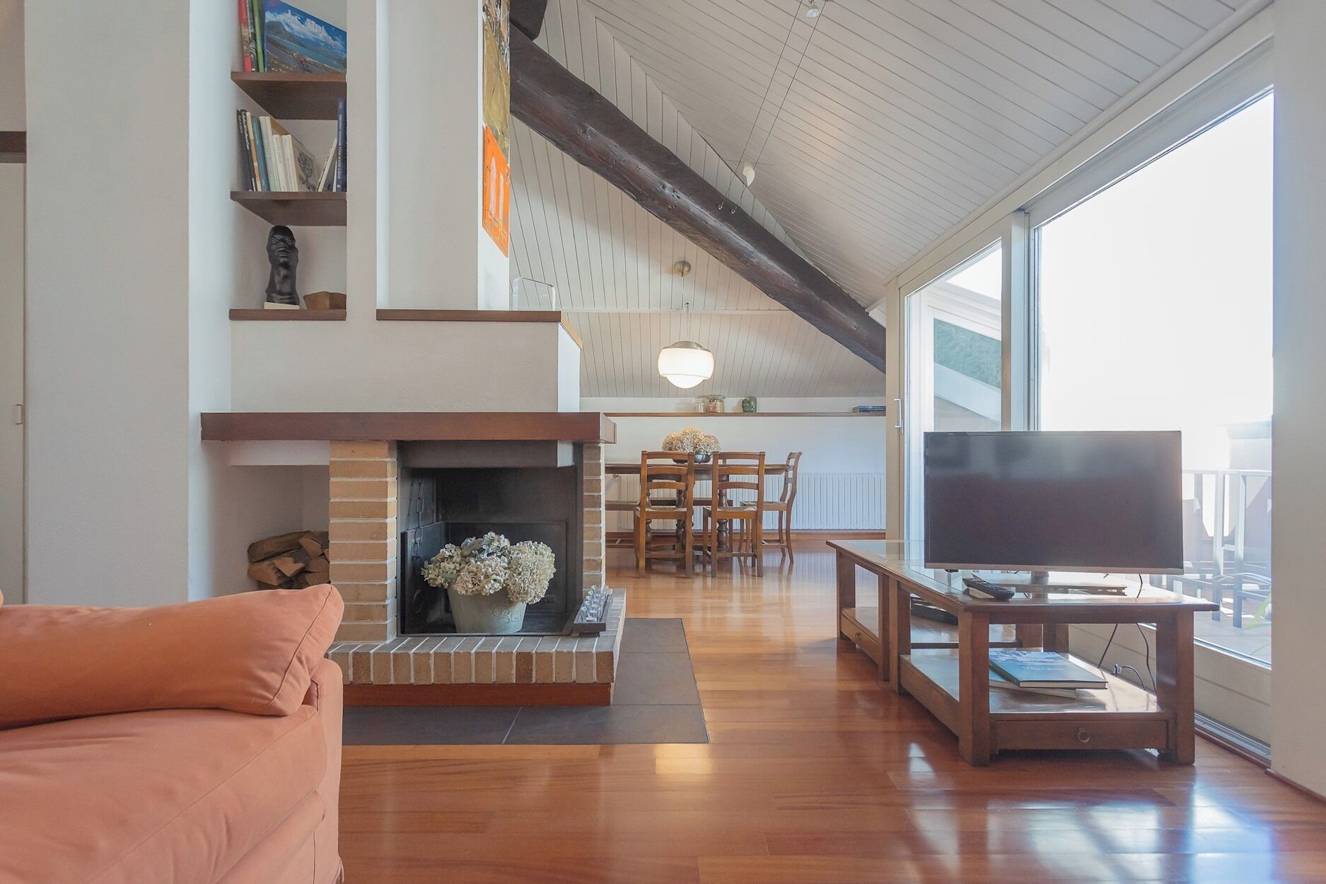 A spacious living room with a fireplace, a television, and a dining area.