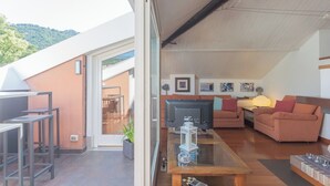 Un salon moderne doté d’une cloison en verre, d’un téléviseur à écran plat, d’un canapé et d’une table basse.