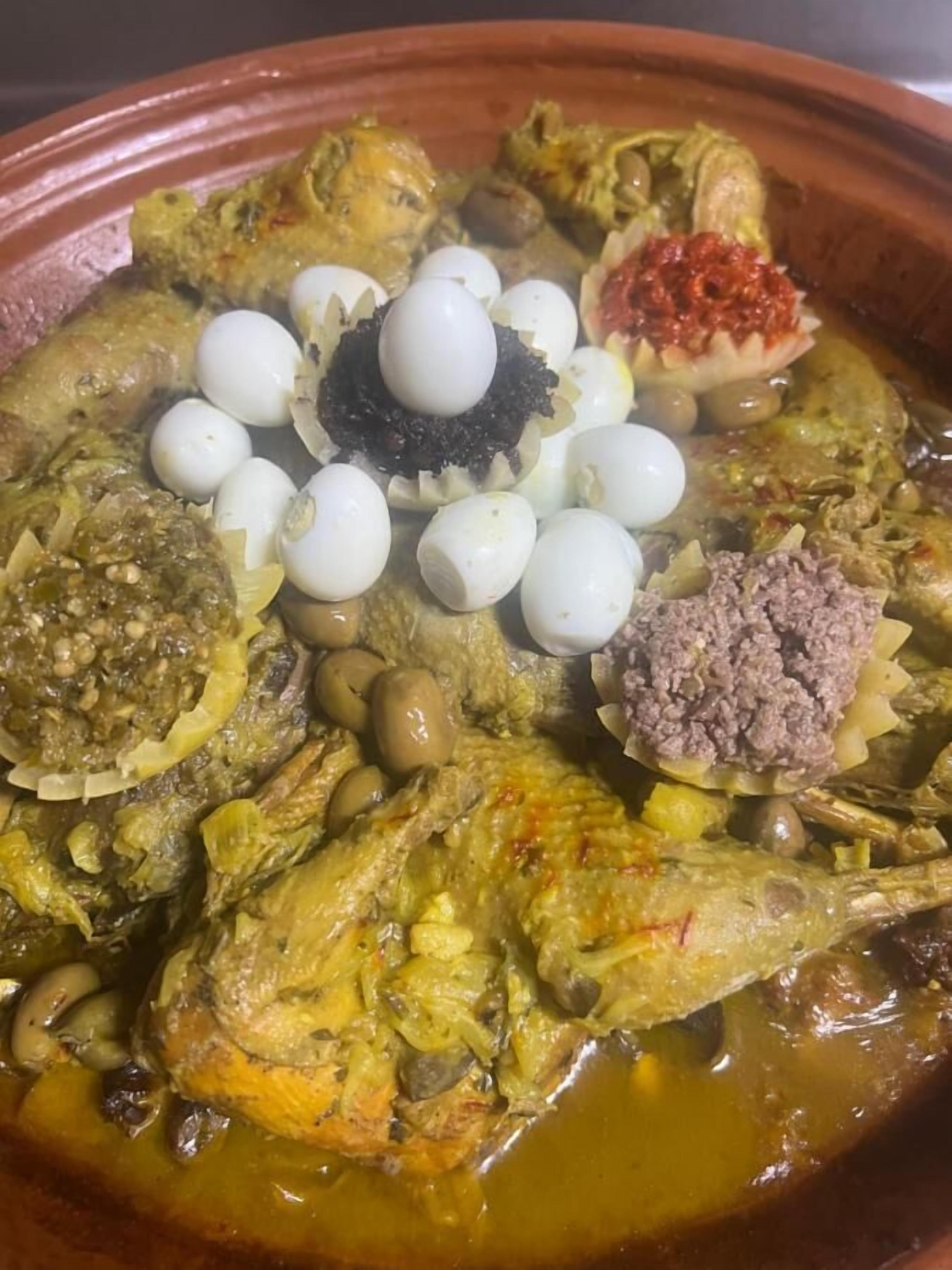 A traditional dish with various ingredients including fish, eggs, olives, and a sauce.