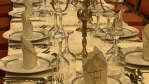 A long dining table set with white plates, silverware, and glassware, adorned with candelabras and candles. - Maison D'hôtes Yamine (Beni Mellal)
