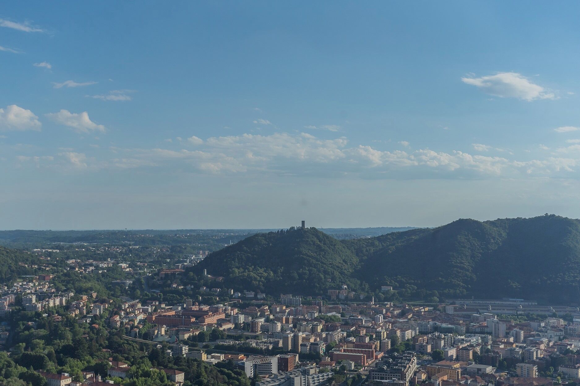 A panoramic view of a city with a prominent hilltop monument.