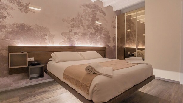 Un dormitorio moderno con una cama grande, una mesita de noche y un espejo.