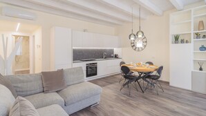 Una sala moderna con un sofá y un comedor con mesa y sillas.