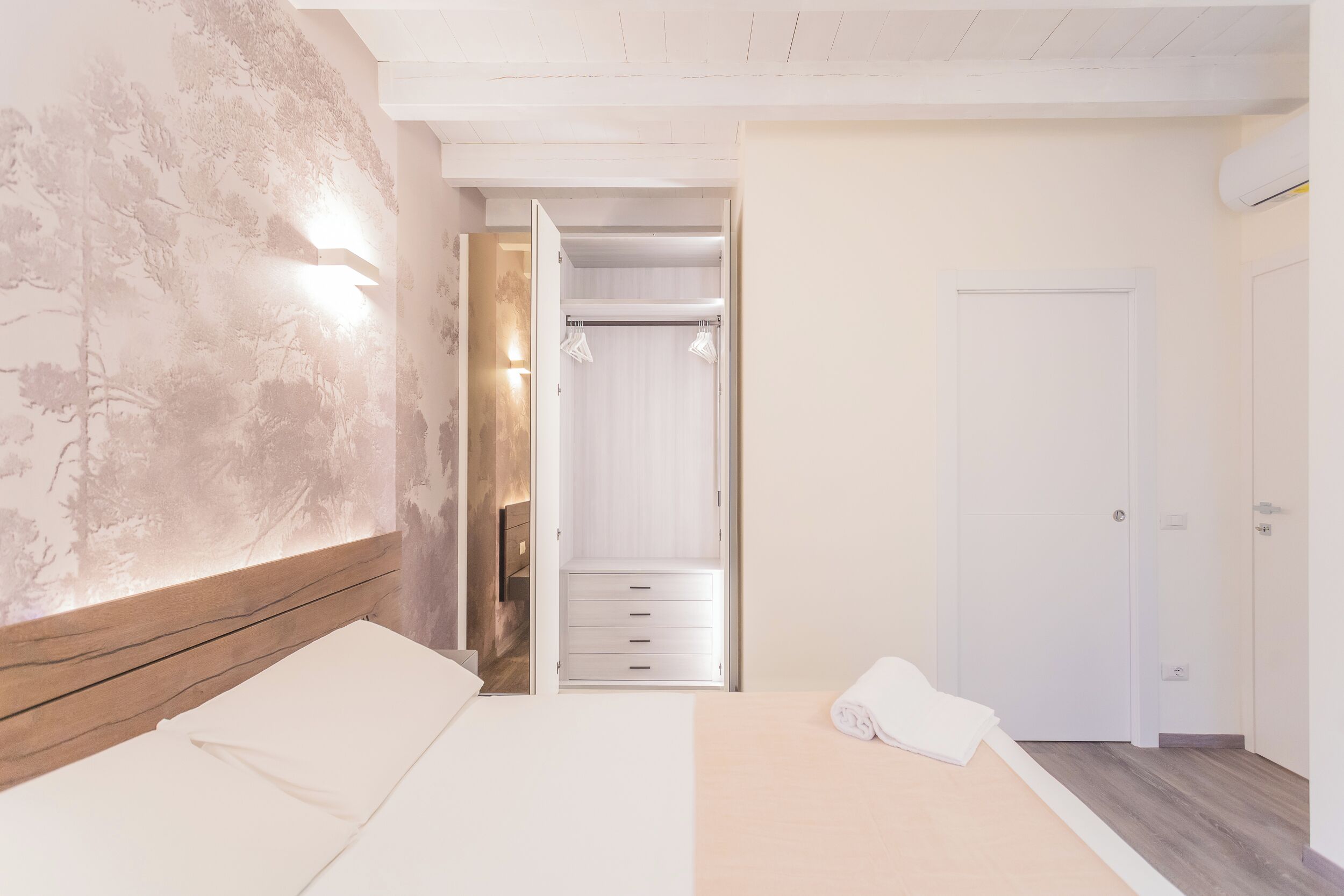 A bedroom with a bed, a wardrobe, and a walk-in closet.