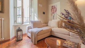 A cozy living room with a beige sofa, a wooden coffee table, and a floor lamp. - Pantero Apartment by Rent all Como (Como)