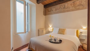 A bedroom with a large bed, a window, a radiator, and a wall with a decorative panel. - Pantero Apartment by Rent all Como (Como)