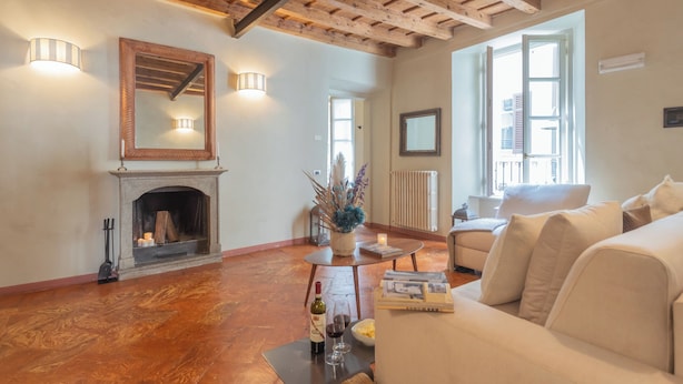 A spacious living room with a fireplace, a sofa, and a dining table. - Pantero Apartment by Rent all Como (Como)