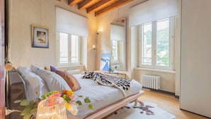 A bedroom with a bed, a large window, a radiator, and a mirror. - Night at the Museum Apartment by Rent all Como (Como)