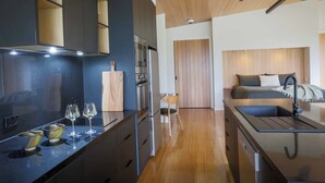 Una cocina moderna con una isla central, electrodomésticos integrados y un área de comedor con sofá y mesa de centro.