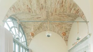 An arched brick ceiling with hanging light fixtures and a large window. - Romantic Escape City Centre With Jacuzzi & Parking by Rent all Como (Como)