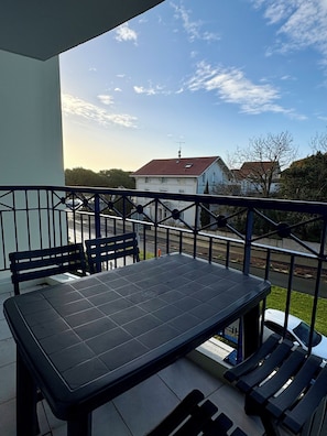 Enjoy the view from this balcony with a table and four chairs overlooking the city.