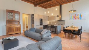 Una sala de estar moderna con un sofá seccional gris, un aparador de madera y un comedor con mesa y sillas de madera.