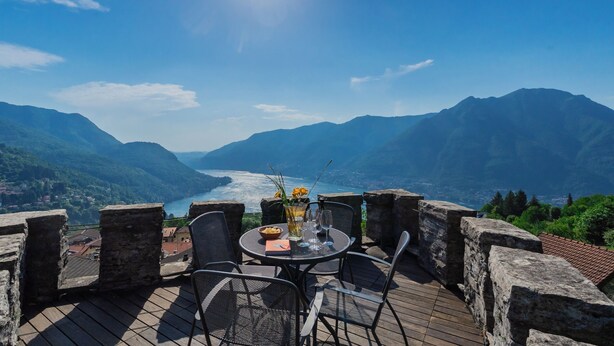 Une table avec des chaises et une vue sur un lac et des montagnes.