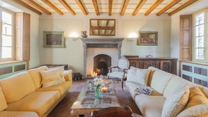 Una sala de estar acogedora con chimenea, dos sofás, una mesa de centro y un espejo.