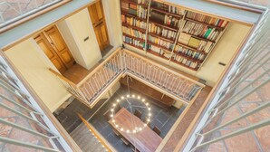 Una biblioteca con una mesa circular central rodeada de estanterías.