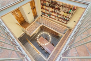 Una biblioteca con una mesa circular central rodeada de estanterías.