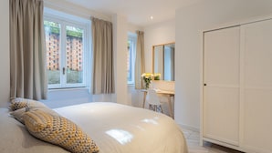 A bedroom with a large bed, a desk with a chair, a wardrobe, and a window with curtains. - Your Private Harbour Nearby George Clooney by Rent all Como (Carate Urio)