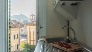A kitchen with a sink and a wooden cutting board with tomatoes. - Zezio 44 by Rent all Como (Como)