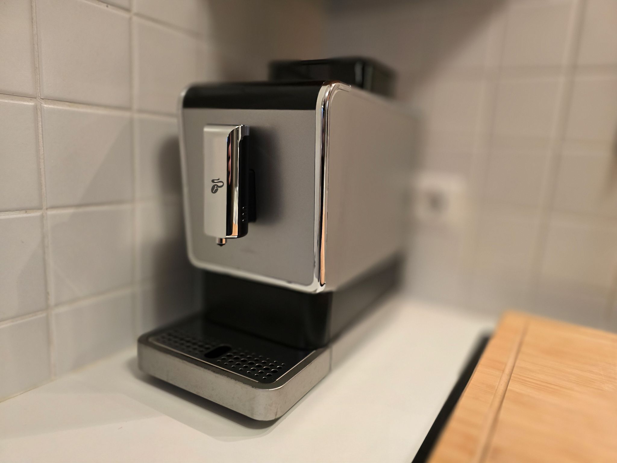 A modern coffee machine with a sleek design, a control panel, and a water reservoir.