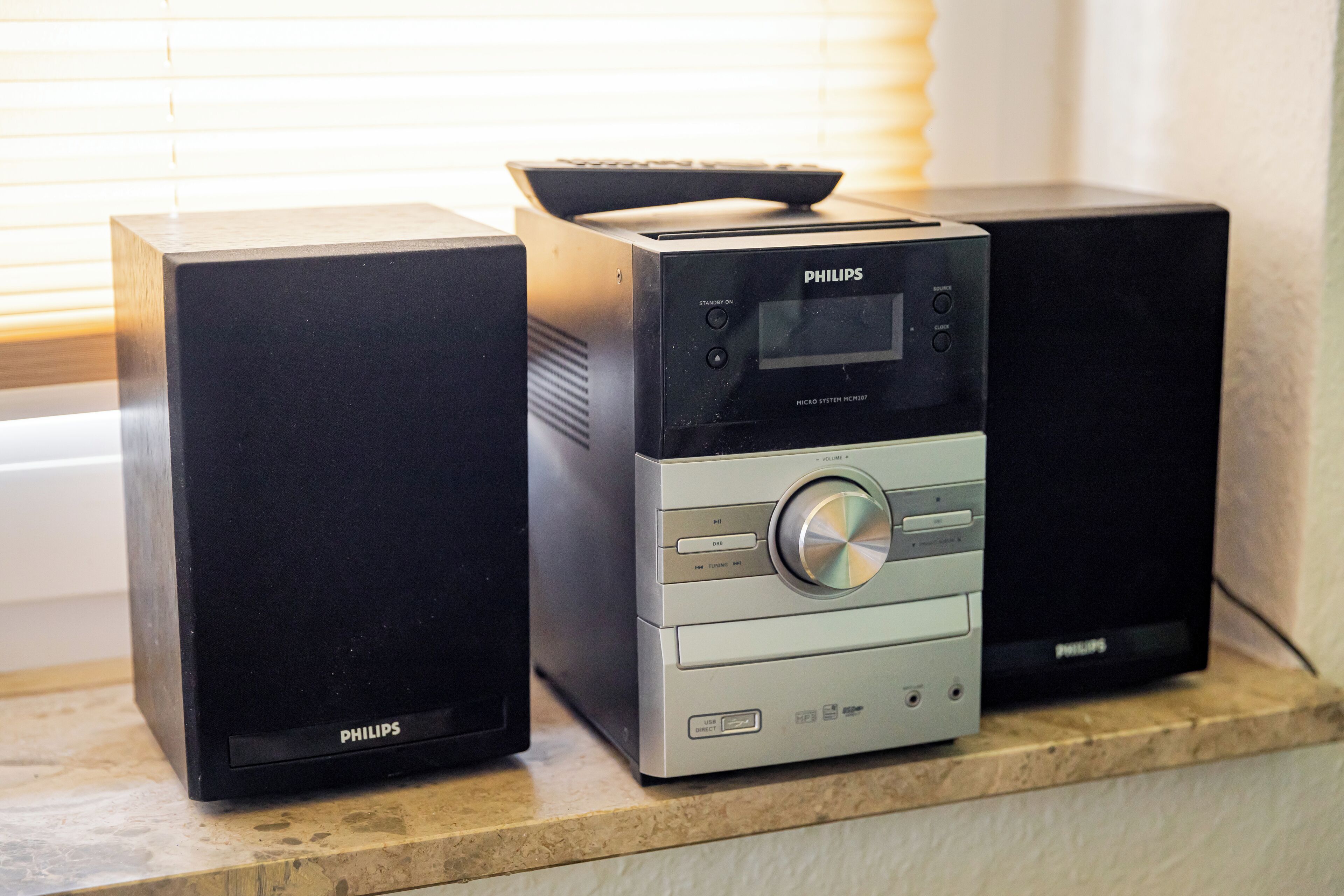 Two black Philips audio systems on a countertop.