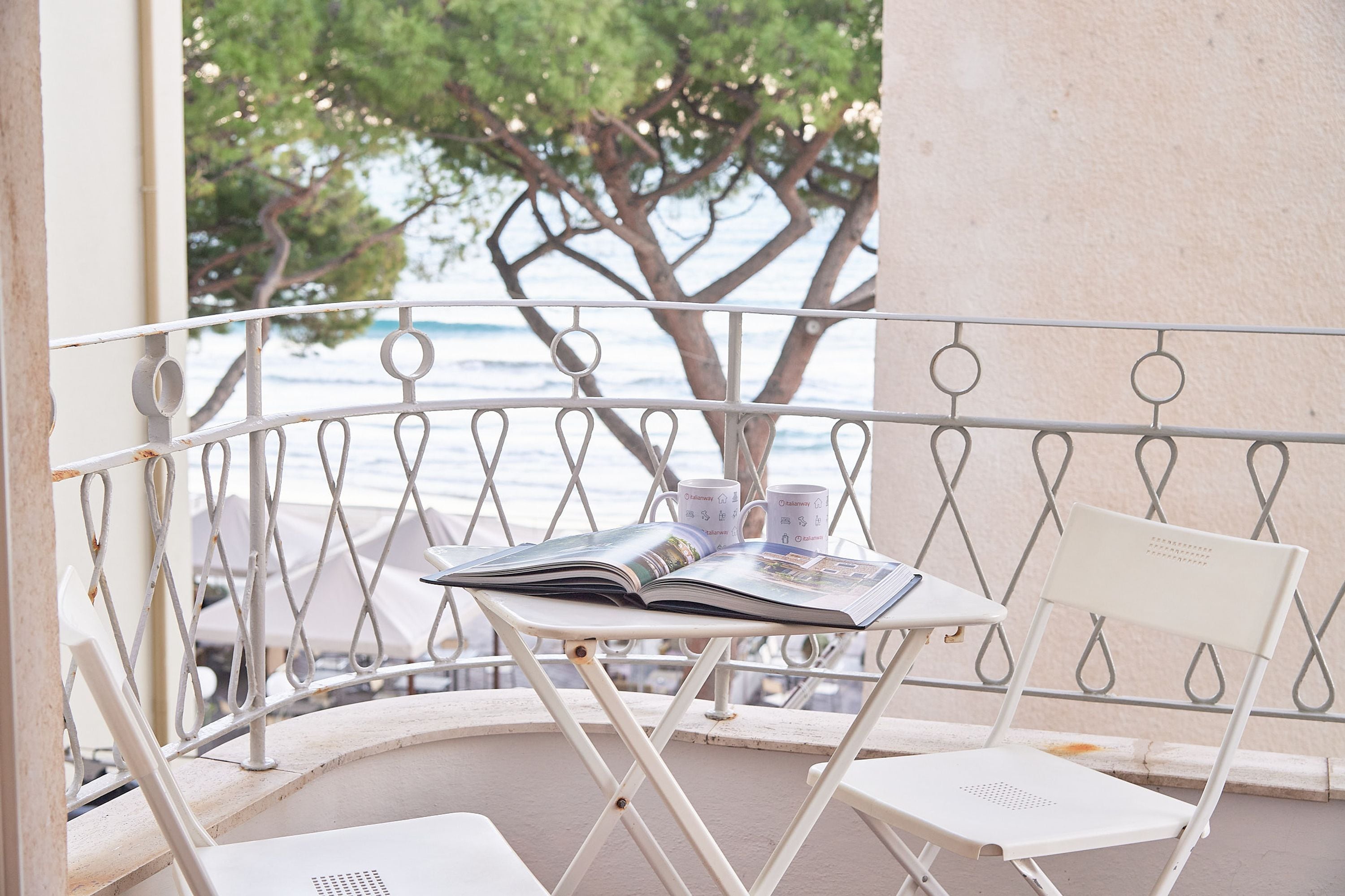 Un balcon avec une table, deux chaises et un magazine.