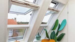 A room with skylights, a plant, and a vase on the windowsill. - Cozy Couple’s Escape (Zoutelande)