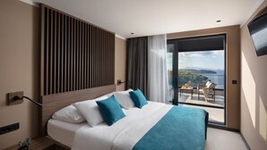 A hotel room with a large bed, a view of the outdoors, and a balcony with seating. - Aminess Alfir Hotel (Blato)