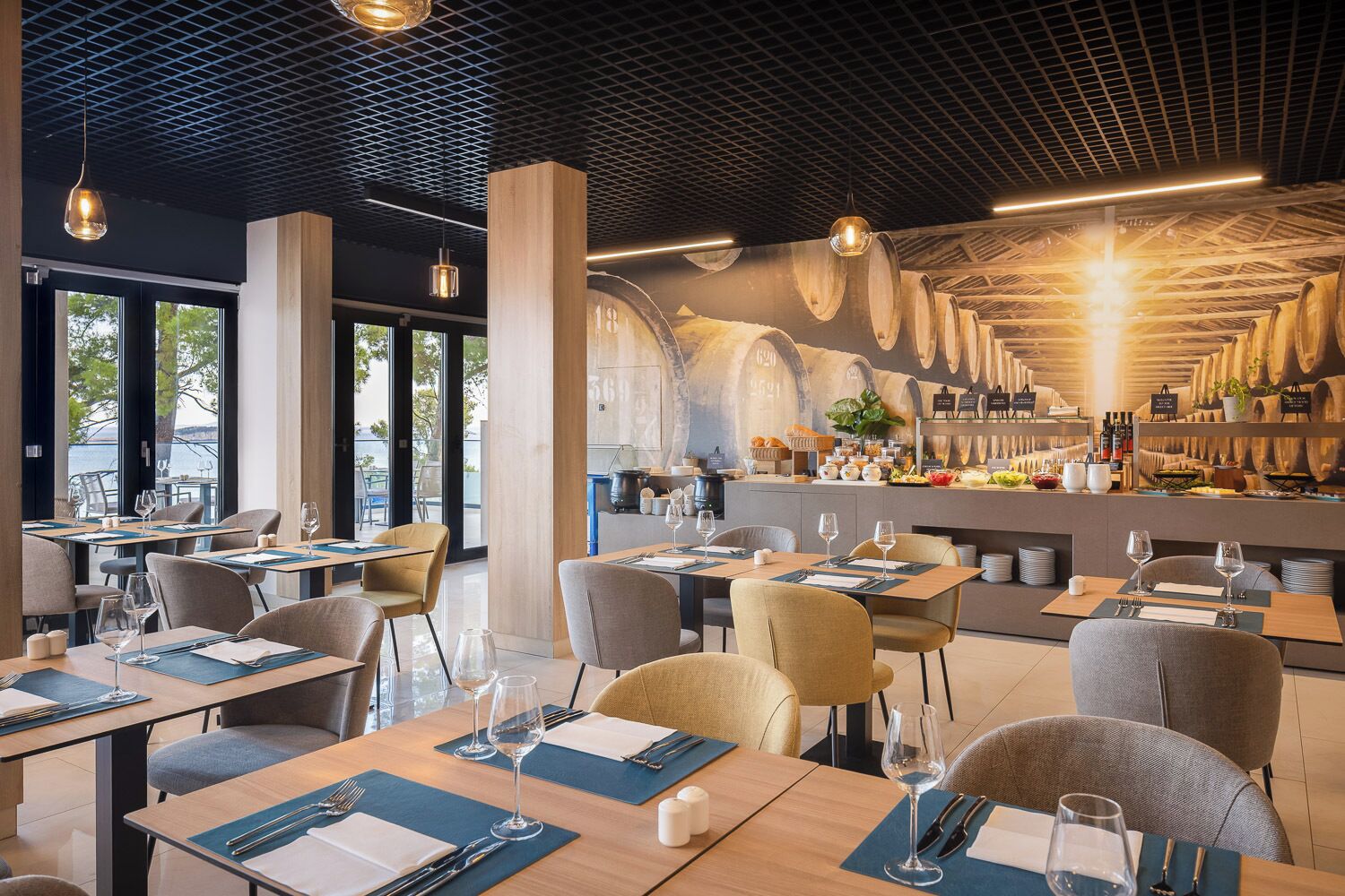 Un restaurante con una decoración moderna, que incluye mesas con individuales azules, sillas e iluminación colgante.