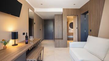 Premium suite with balcony and partial sea view | Living area | TV