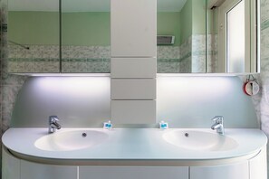 A bathroom with two sinks, a mirror, and a towel rack. - Casa Cotima (Campione d'Italia)