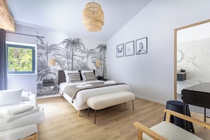 A modern bedroom with a bed, bedside tables, a hanging light fixture, and a large window. - Renovated, spacious and comfortable 26-bed mill (Saint-Ignat)