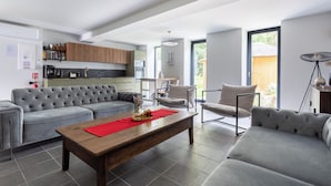 A modern living room with a grey sectional sofa, a wooden coffee table, and a red placemat. - Renovated, spacious and comfortable 26-bed mill (Saint-Ignat)