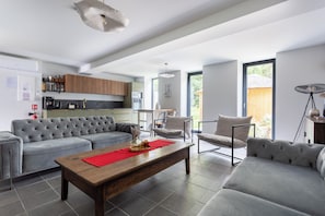 A modern living room with a grey sectional sofa, a wooden coffee table, and a red placemat. - Renovated, spacious and comfortable 26-bed mill (Saint-Ignat)