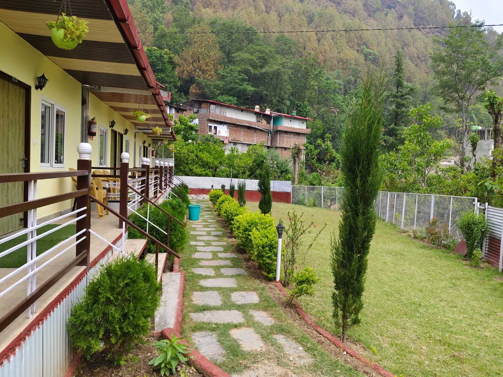 A hotel with a stone pathway leading to a covered outdoor area with seating.