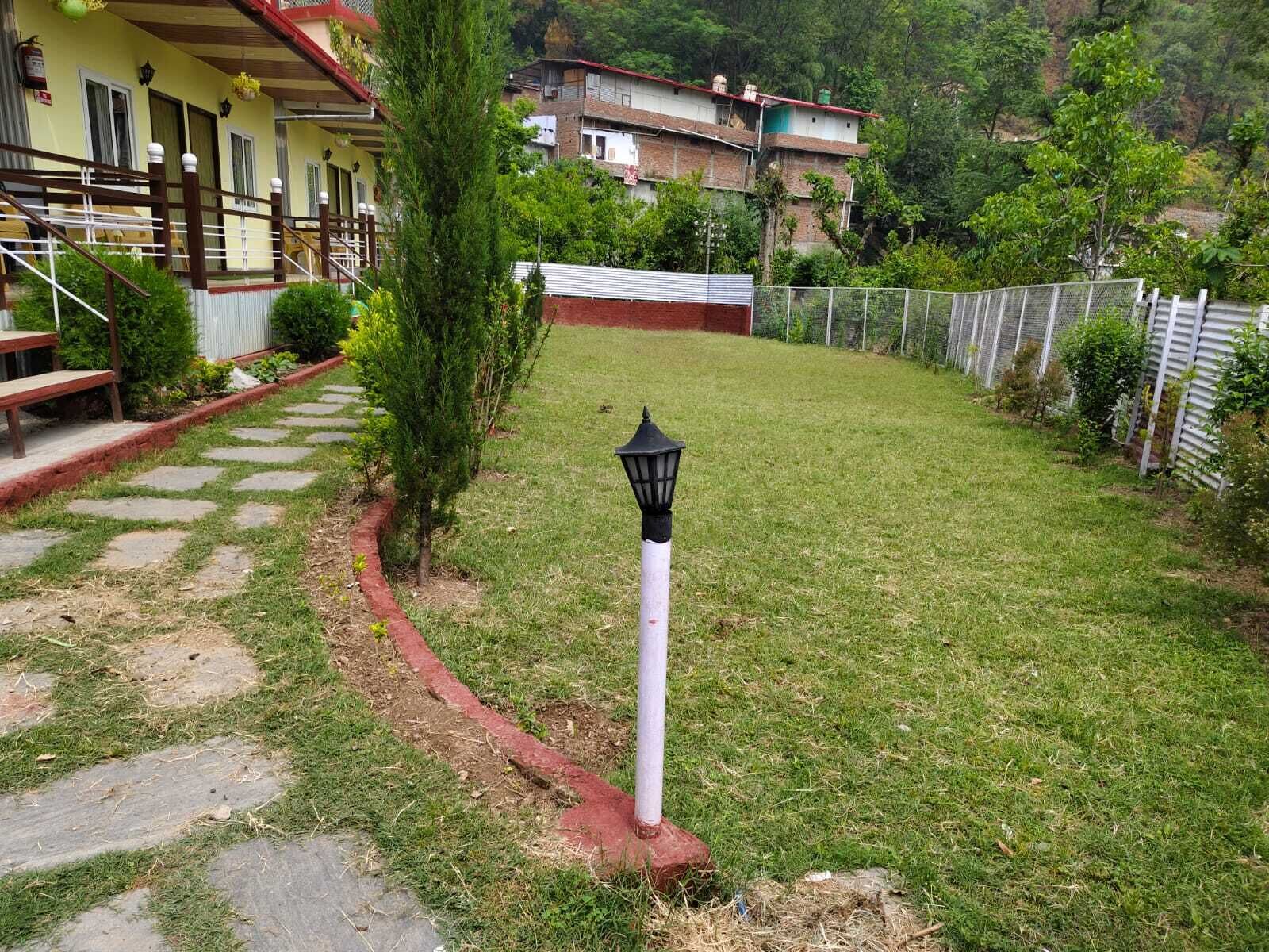 A well-maintained lawn with a pathway leading to a building with a red roof and white trim.