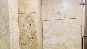 Un baño pequeño con azulejos, un inodoro, un lavamanos y una ducha.